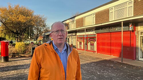 Cllr Stephen Fenton at the car park entrance and in front of the shops.