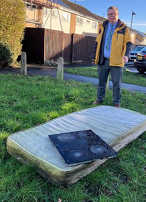 Cllr Waller stood over fly-tipped waste