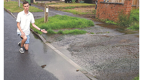 Campaigner Caleb Pell at the location where gallons of water are pouring on to the road in Tuke Avenue